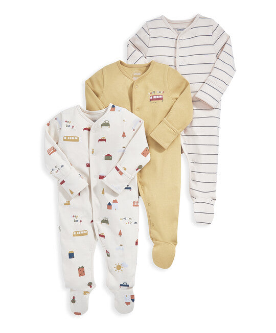 Three baby footed sleepers arranged in a fan shape on a white background. The top sleeper is cream with thin gray stripes, the middle sleeper is solid pale yellow, and the bottom sleeper is off-white with small multicolor house and vehicle prints.